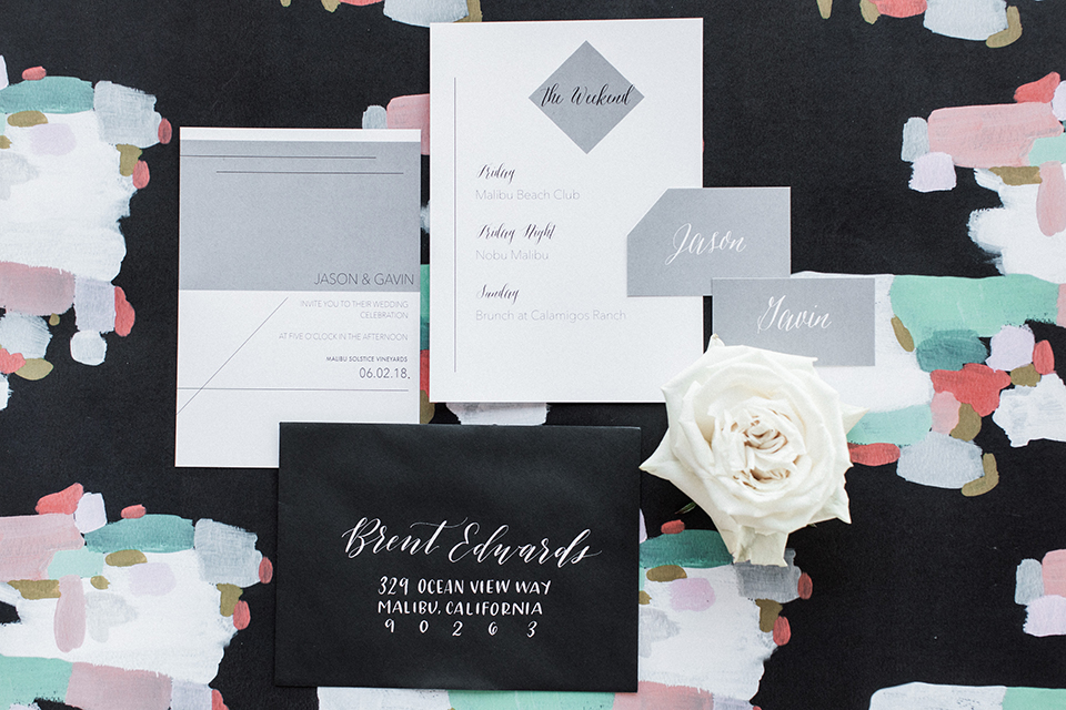 Los angeles same sex outdoor wedding at malibu solstice canyon wedding invitations black envelope with calligraphy writing and white invitations with grey decor on white floral background wedding photo idea for invitations