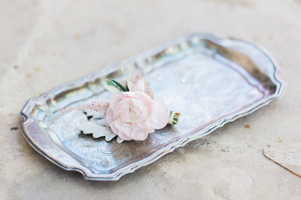 Fall wedding at the villa san juan capistrano wedding decor silver antique tray with white floral boutonniere on top with the tray on the ground wedding photo idea for decor and boutonniere