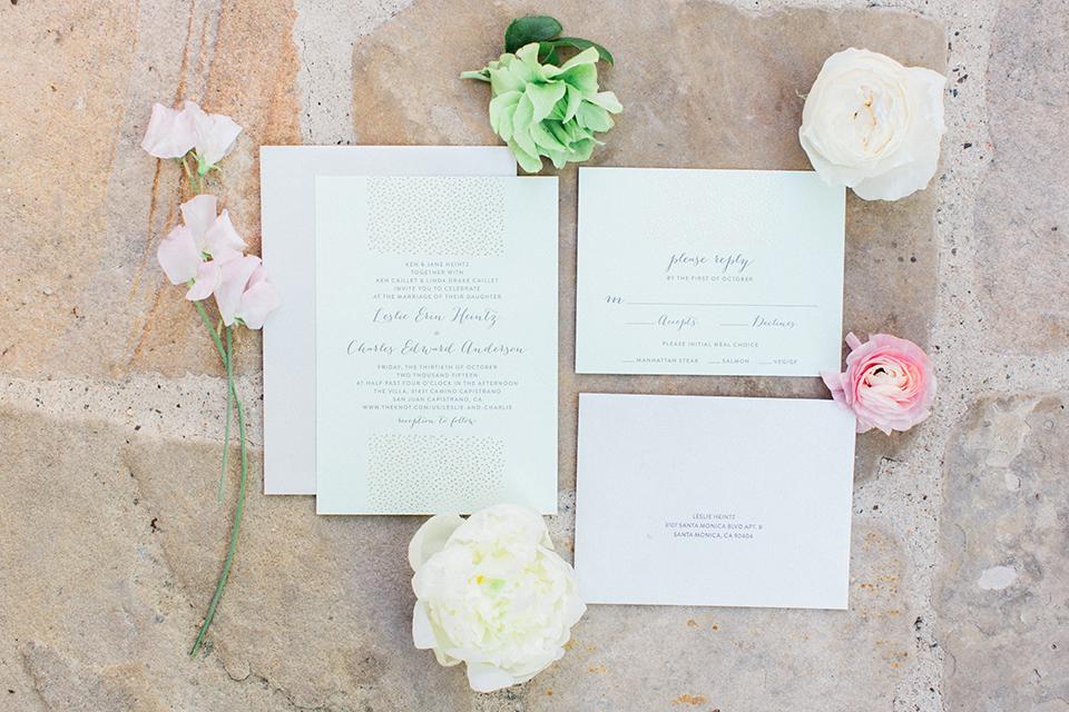 Fall wedding at the villa san juan capitrano wedding invitations white invitations with small black cursive writing and white and green flower decor on brick background wedding photo idea for wedding invitations