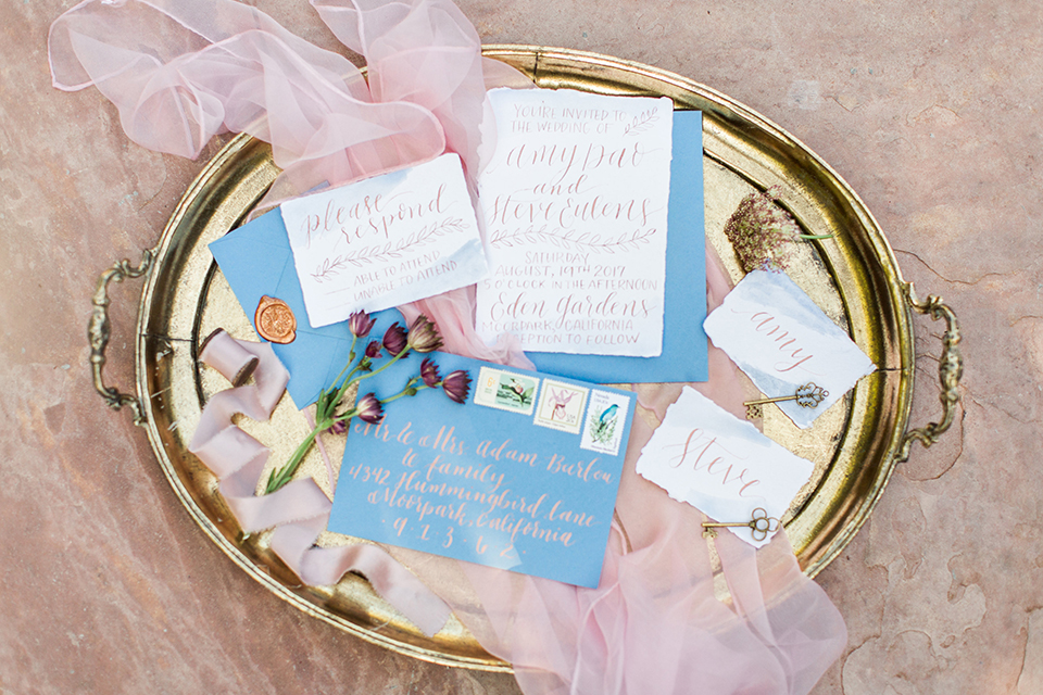 Los angeles outdoor wedding at eden gardens wedding invitations gold tray with white and blue invitations with blue envelopes and pink tulle decor wedding photo idea for invitations