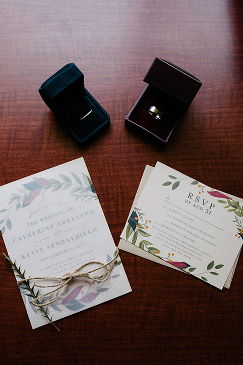 San diego autumn inspired outdoor wedding at limoneira ranch wedding invitations white with greenery flower design on invitations and dark blue ring boxes with rings inside and rustic decor on dark wood background wedding photo idea for invitations