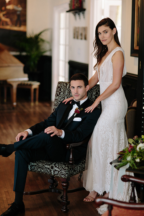 Southern-california-wedding-at-the-ebell-of-long-beach-bride-and-groom-holding-hands-with-bouquet-bride-wearing-a-lace-a-line-dress-with-straps-and-hair-in-loose-down-waves-and-groom-in-navy-tux-with-black-trim-and-black-bowtie