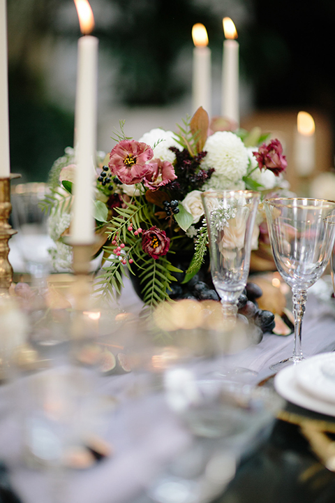 Southern-california-wedding-at-the-ebell-of-long-beach-table-set-up-with-flowers-and-candle-decor-wooden-chairs-and-table-with-white-and-chamange-toned-linnens-and-greenery-as-floral-arrangements