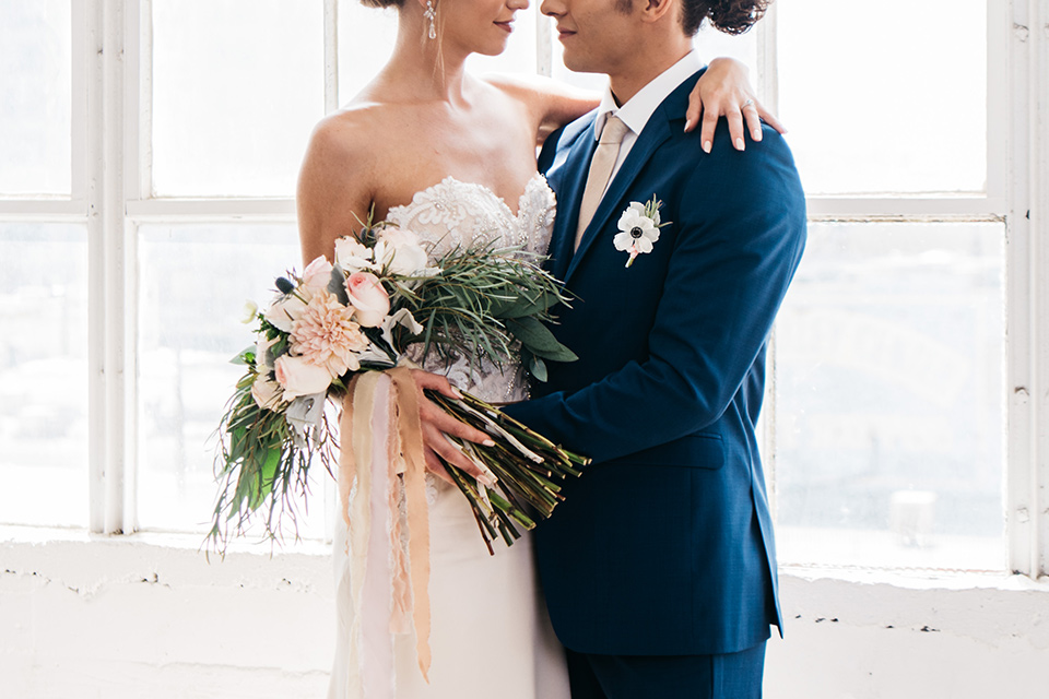 FD-Studios-bride-and-groom-close-up-bride-in-a-strapless-flowing-gown-groom-in-a-dark-blue-suit-with-a-blush-long-tie