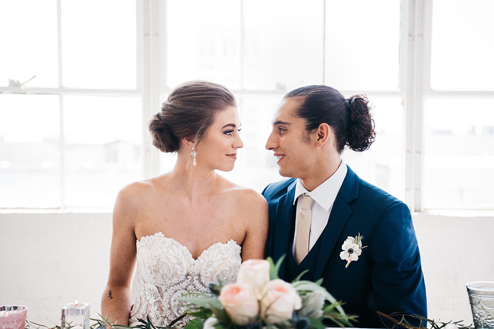 FD-Studios-bride-and-groom-looking-at-each-other-bride-in-a-strapless-flowing-gown-groom-in-a-dark-blue-suit-with-a-blush-long-tie