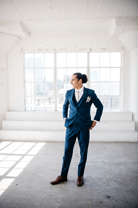 FD-Studios-groom-standing-alone-groom-in-a-dark-blue-suit-with-a-blush-long-tie