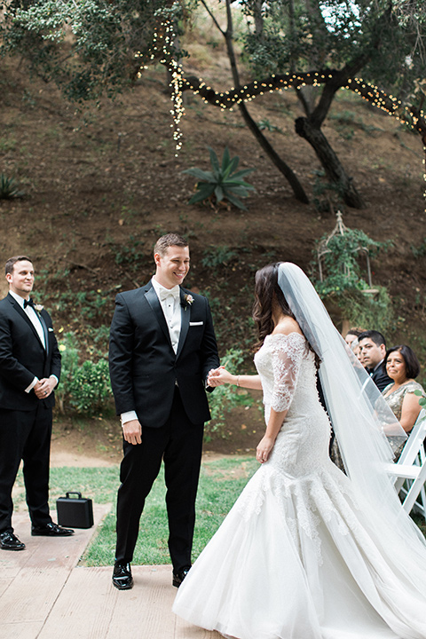 los-willows-wedding-bride-and-groom-beginning-ceremony-bride-alone-final-bride-in-a-tulle-ballgown-with-sleeves-groom-in-a-traditional-black-tuxedo-with-black-bow-tie-and-tux-shoes