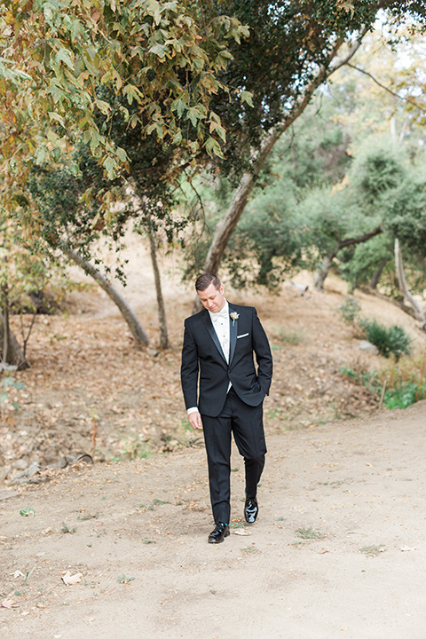 los-willows-wedding-groom-walking-in-a-traditional-black-tuxedo-with-black-bow-tie-and-tuxed-shoes