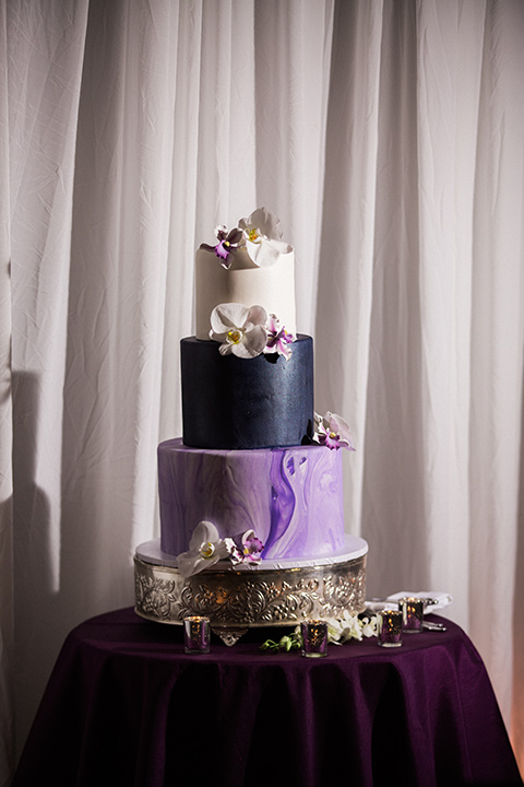 Avenue-of-the-arts-wedding-cake-three-tiers-with-different-purple-fondant-and-florals