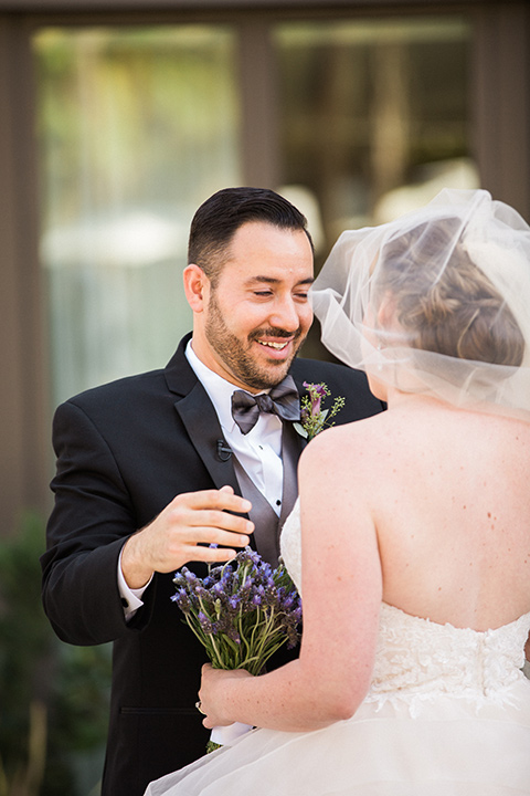 Avenue-of-the-arts-wedding-first-look-bride-in-tulle-ball-gown-with-beaded-bodice-and-beaded-headband-groom-inblack-tuxedo-with-a-silver-vest-and-silver-bowtie