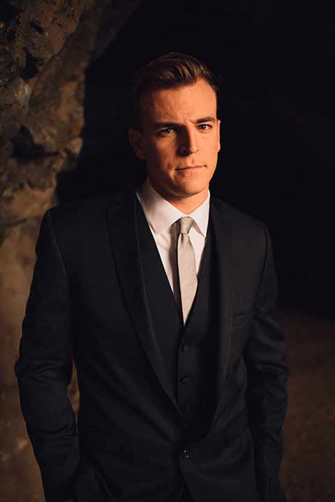 bronson-caves-elopement-shoot-close-up-of-the-groom-in-cave-groom-wore-a-navy-suit-with-a-silver-tie