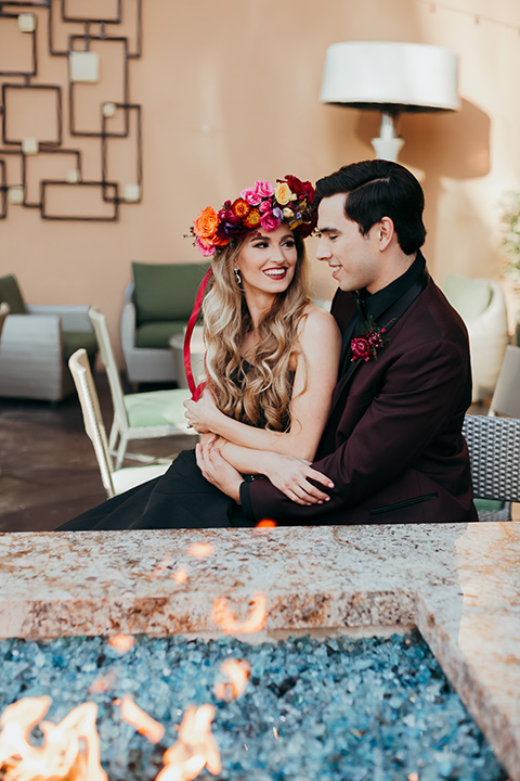 dia-de-los-muertos-cheers-bride-in-a-black-dress-with-floral-headpiece-groom-in-burgundy-tux-with-black-shirt-and-bow-tie