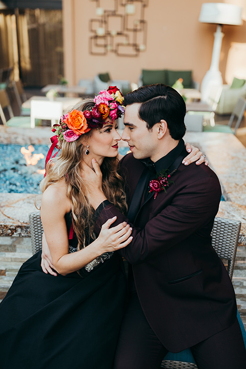 dia-de-los-muertos-drinking-bride-in-a-black-dress-with-floral-headpiece-groom-in-burgundy-tux-with-black-shirt-and-bow-tie