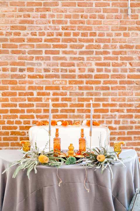 estate-on-second-shoot-sweetheart-table-grey-linens-with-the-brick-background-and-white-high-candles