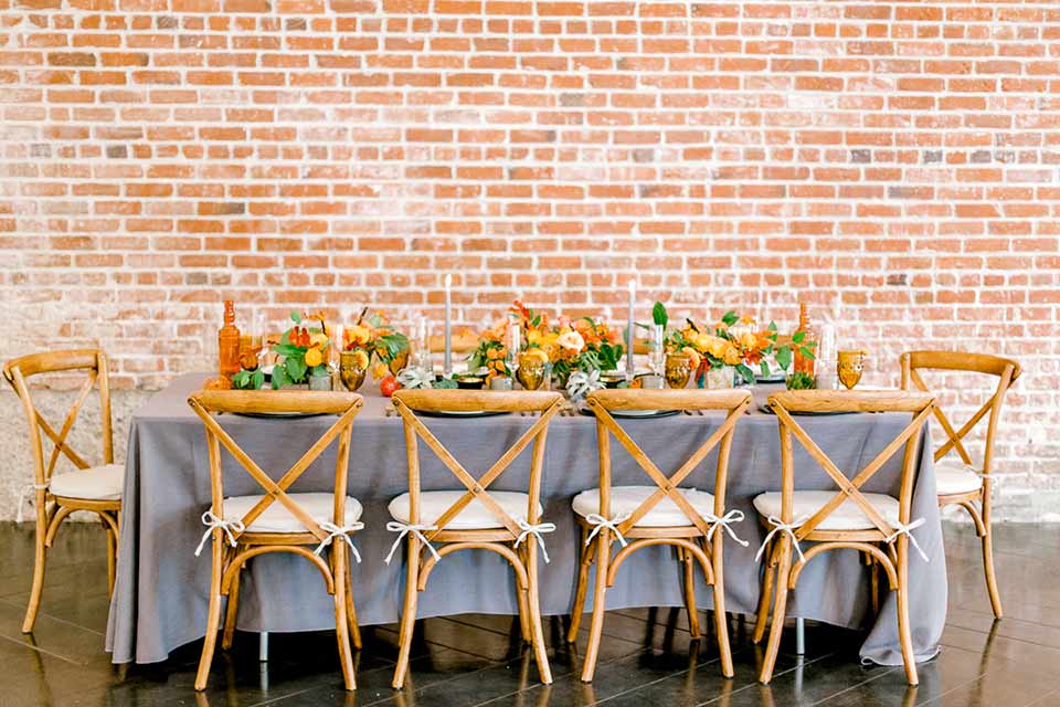 estate-on-second-shoot-table-set-up-brick-walls-wooden-chairs-and-grey-linen