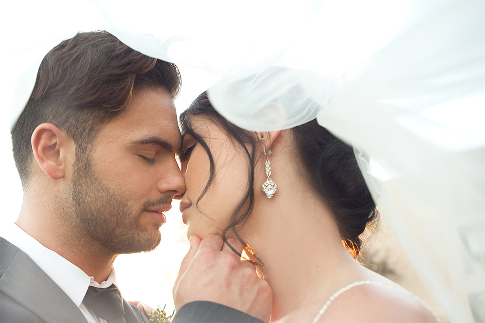 Grand-Pacific-Palisades-Groom-in-charcoal-tuxedo-with-a-long-black-tie-bride-in-a-lace-dress-with-straps