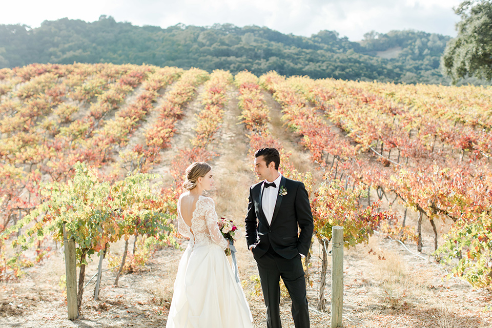 hammersky-editorial-shoot-bride-and-groom-looking-at-each-other-bride-in-a-tulle-ballgown-with-lace-sleeves-and-high-neckline-groom-in-a-black-shawl-lapel-tuxedo-with-black-bow