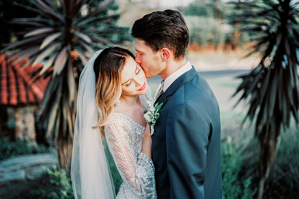 MUCKENTHALER-SHOOT-bride-and-groom-close-up-bride-in-fitted-satin-long-sleeve-gown-groom-in-a-slate-blue-suit-with-a-ivory-bow-tie