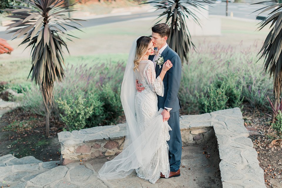 MUCKENTHALER-SHOOT-bride-and-groom-embrace-bride-in-fitted-satin-long-sleeve-gown-groom-in-a-slate-blue-suit-with-a-ivory-bow-tie