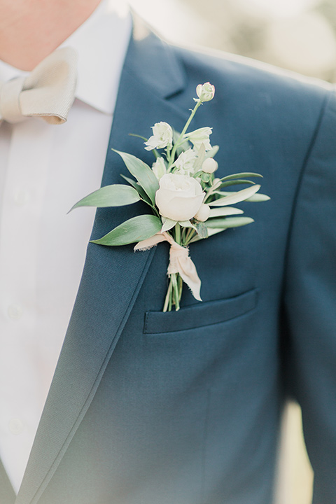 MUCKENTHALER-SHOOT-close-up-on-coat-groom-in-a-slate-blue-suit-with-a-ivory-bow-tie