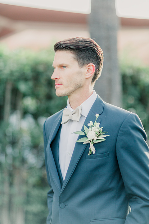 MUCKENTHALER-SHOOT-groom-groom-in-a-slate-blue-suit-with-a-ivory-bow-tie