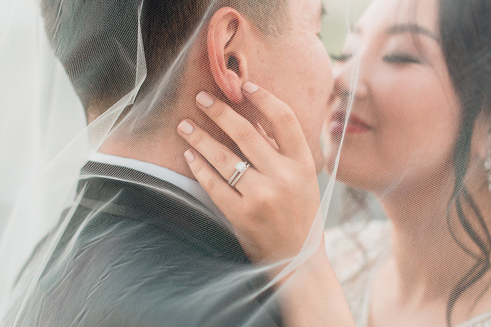 occidental-college-wedding-bride-and-groom-under-veil-groom-in-black-tuxedo-bride-in-a-fitted-gown-with-a-beaded-bodice