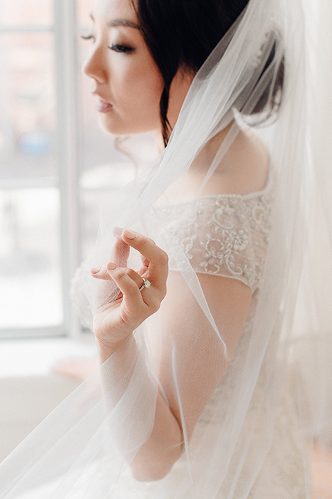 occidental-college-wedding-bride-putting-on-shoes-bride-in-a-fitted-gown-with-a-beaded-bodice