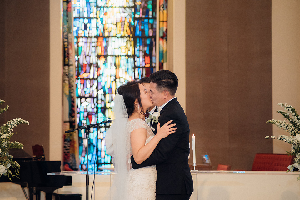 occidental-college-wedding-first-kiss-groom-in-black-tuxedo-bride-in-a-fitted-gown-with-a-beaded-bodice