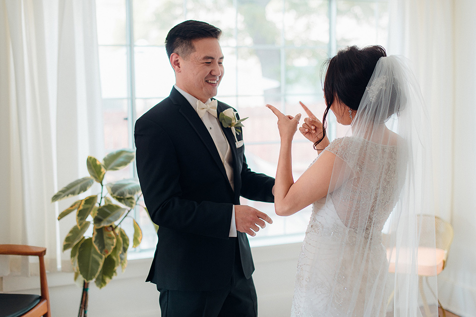 occidental-college-wedding-first-look-groom-in-black-tuxedo-bride-in-a-fitted-gown-with-a-beaded-bodice