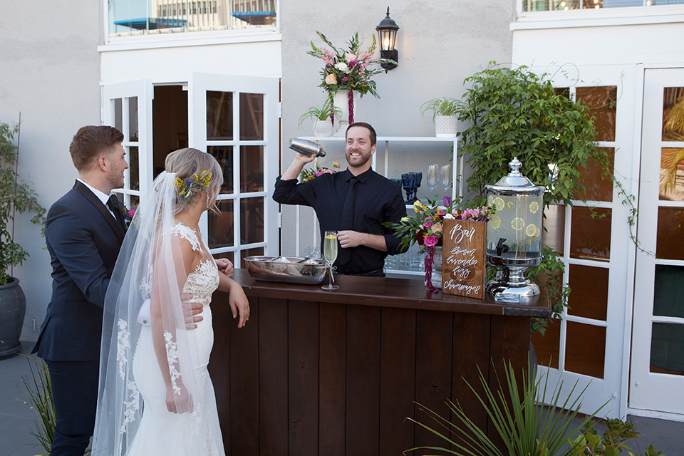 parq-west-shoot-bride-and-groom-at-the-bar-bride-wearing-a-flowing-gown-with-an-illusion-lace-bodice-and-cap-sleeves-groom-in-a-charcoal-tuxedo-with-a-black-satin-shawl-lapel