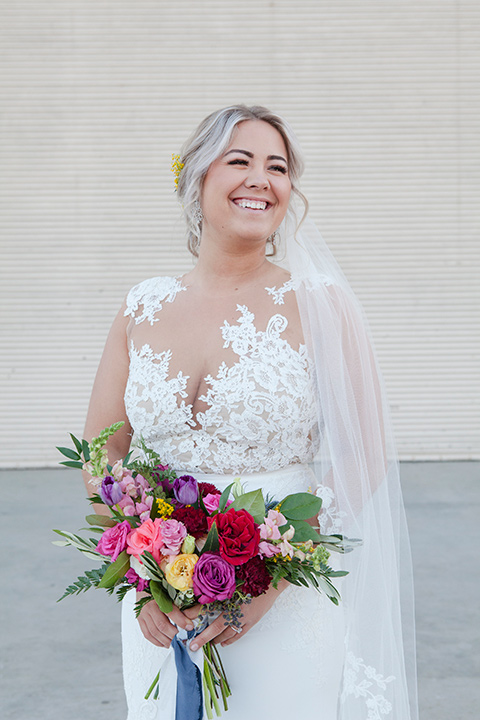 parq-west-shoot-bride-smiling-alone-bride-wearing-a-flowing-gown-with-an-illusion-lace-bodice-and-cap-sleeves