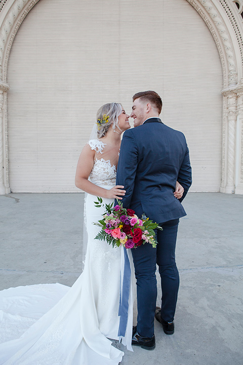 parq-west-shoot-groom-back-facing-camera-bride-looking-at-him-about-to-kiss-bride-wearing-a-flowing-gown-with-an-illusion-lace-bodice-and-cap-sleeves-groom-in-a-charcoal-tuxedo-with-a-black-satin-shawl-lapel