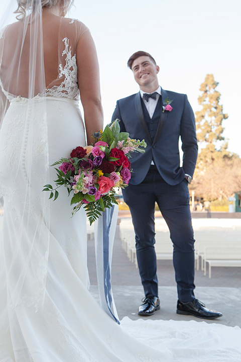 parq-west-shoot-groom-looking-at-bride-first-look-bride-wearing-a-flowing-gown-with-an-illusion-lace-bodice-and-cap-sleeves-groom-in-a-charcoal-tuxedo-with-a-black-satin-shawl-lapel