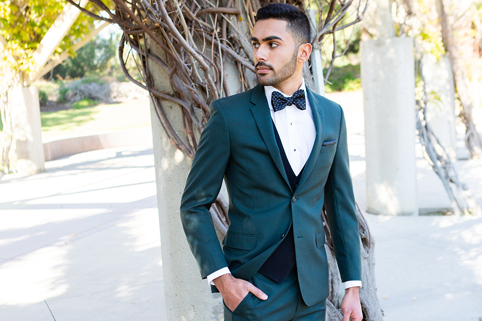 green-suit-coat-and-pants-with-a-black-vest-and-patterned-bow-tie