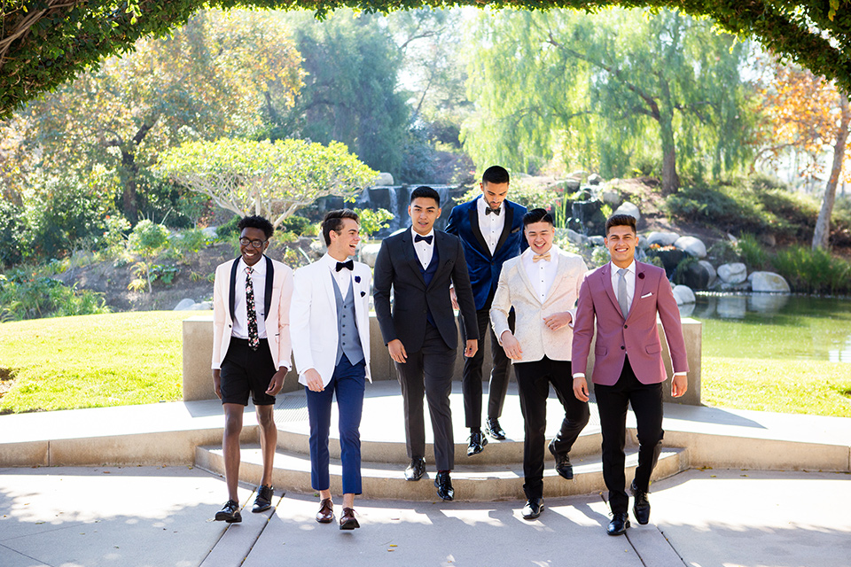 group-walking-down-stairs-in-their-wide-array-of-tuxedo-colors-for-prom