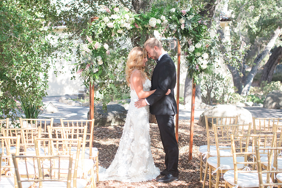 rockwood-shoot-bride-and-groom-at-ceremony-space-bride-in-a-ball-gown-with-her-hair-down-and-blingy-jewelry-groom-in-a-traditional-black-tuxedo-with-black-bow-tie