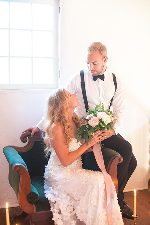 rockwood-shoot-bride-and-groom-in-chair-looking-at-each-other-bride-in-a-ball-gown-with-hair-down-and-groom-in-black-tuxedo