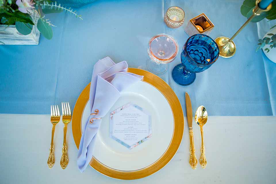 seapoint-bridal-shoot-table-settings-blue-linen-gold-and-pink-accents