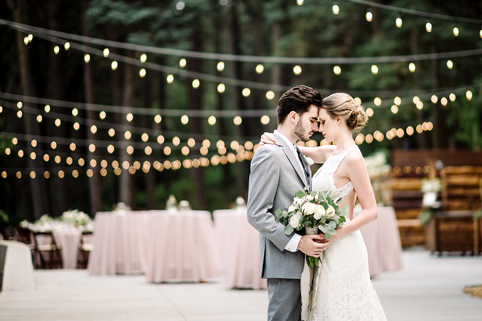 skypark-styled-shoot-bride-and-groom-first-dance-bride-in-lace-fitted-dress-with-ca-sleeves-and-a-keyhole-back-detail-groom-in-grey-suit-with-brown-shoes-and-ivory-long-tie