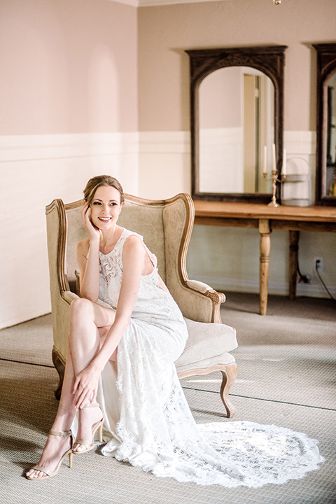 skypark-styled-shoot-bride-sitting-in-chair-bride-in-lace-fitted-dress-with-a-sleeves-and-a-keyhole-back-detail