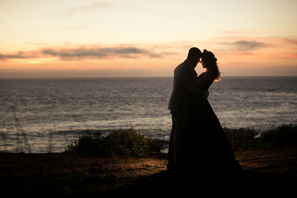 Terranea-styled-shoot-bride-and-groom-at-sunset-bride-in-a-midnight-blue-dress-with-an-illusion-neckline-with-jewels-on-bodice-her-hair-down-in-a-loose-wave-groom-in-a-light-grey-suit-with-a-blue-bow-tie-to-match-the-bride