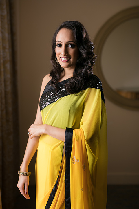 Terranea-styled-shoot-bride-in-yellow-dress-smiling-at-camera-bride-in-yellow-sarees-with-hair-in-a-loose-wave-with-gold-teardrop-earrings