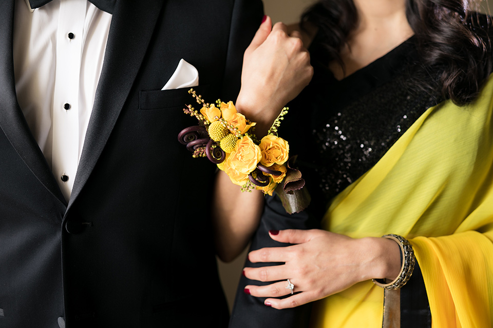 Terranea-styled-shoot-close-up-of-florals-bride-in-yellow-sarees-with-hair-in-a-loose-wave-groom-in-a-tradtitional-black-tuxedo-with-a-black-bowtie-and-black-vest-with-wearing-a-black-and-yellow-florals