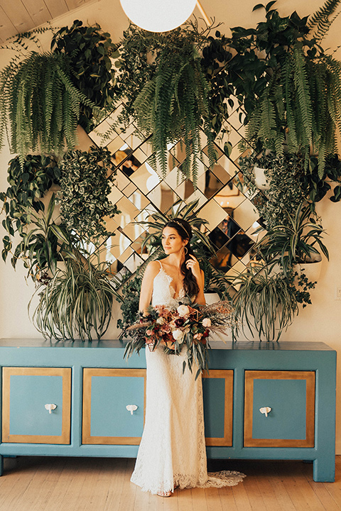 The-Ruby-Street-photoshoot-bride-standing-by-blue-table-bride-wearing-a-lace-bohemian-style-dress