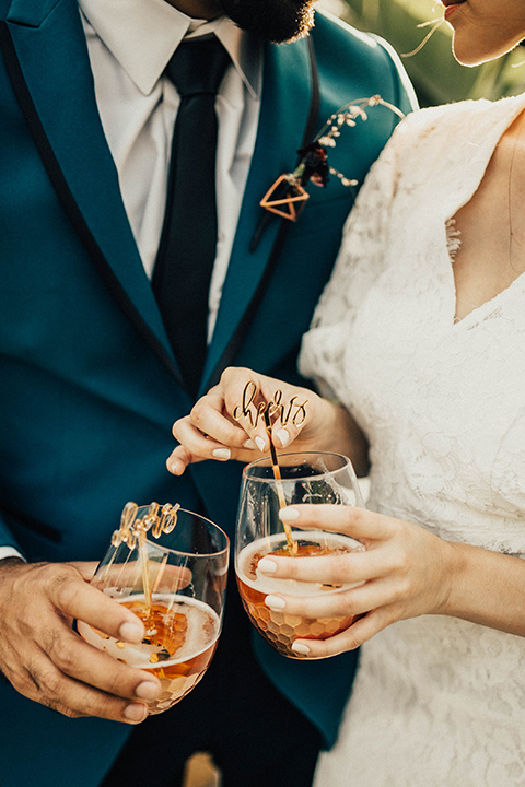 The-Ruby-Street-photoshoot-close-up-on-drinks-groom-wearing-a-teal-blue-tuxedo-and-the-bride-wearing-a-lace-dress