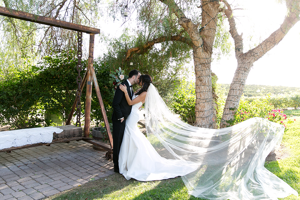 Villa-de-Amore-bride-and-groom-kissing-with-her-veil-blowing-in-the-wind