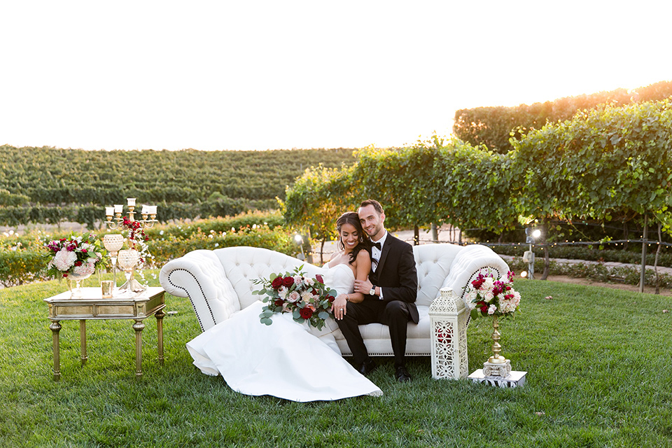 Villa-de-Amore-bride-and-groom-on-couch-bride-in-a-fitted-gown-groom-in-a-black-tuxedo