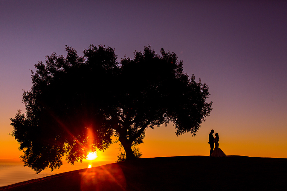 Los-Verdes-Golf-Course-Wedding-bride-and-groom-at-sunset-bride-is-in-a-lace-mermaid-style-gown-with-a-modified-sweetheart-neckline-the-groom-is-in-a-navy-blue-tuxedo-with-a-black-shawl-lapel-and-a-black-bow-tie