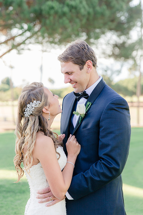 Los-Verdes-Golf-Course-Wedding-bride-and-groom-looking-at-each-other-bride-in-white-lace-mermaid-gown-and-the-groom-is-in-a-navy-blue-shawl-lapel-tuxedo-and-black-bow-tie