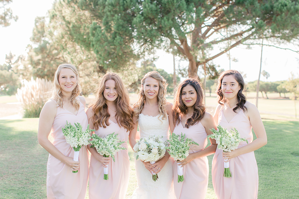 Los-Verdes-Golf-Course-Wedding-bridesmaids-bridesmaids-in-light-pink-short-dresses-bride-is-in-a-lace-mermaid-style-gown-with-a-modified